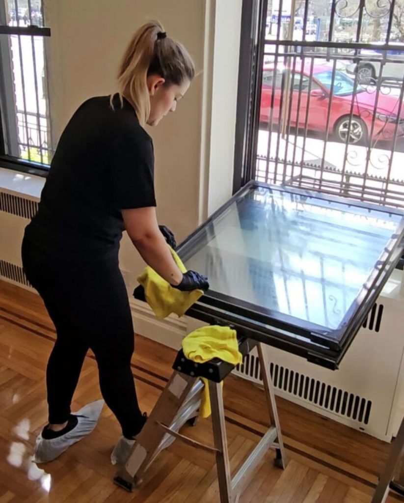 "Cleaning technician removing construction dust from exterior window frame and window trough after renovation