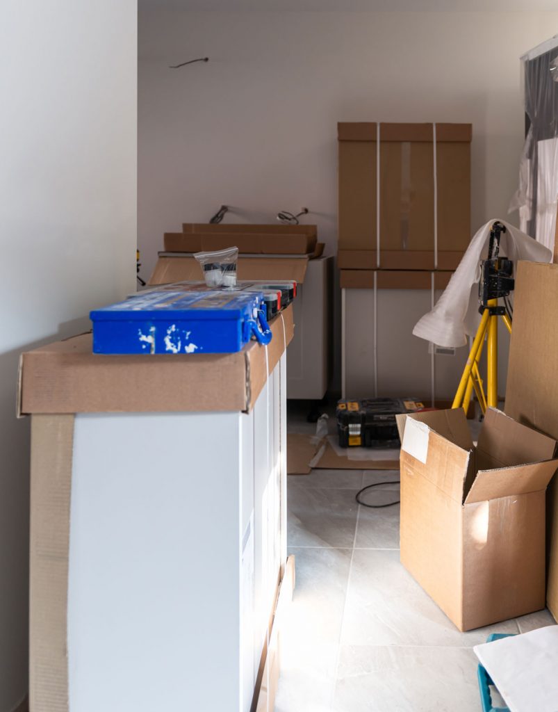 Residential renovation project before post construction cleaning with construction materials, dust, boxes, and unfinished interior awaiting final cleanup and move-in preparation